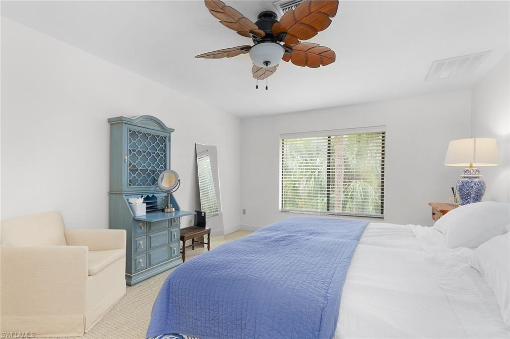 3360 10th Street North, Unit 1210 Naples, FL 34103 - Photo 18 of 28 a bed room with a bed and a chandelier