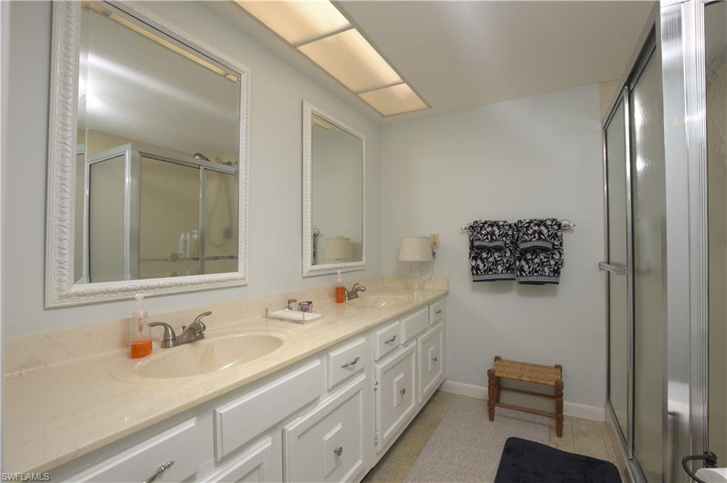 3360 10th Street North, Unit 1210 Naples, FL 34103 - Photo 19 of 28 a bathroom with a sink double vanity and a mirror