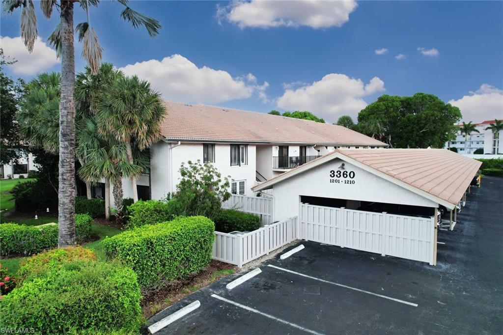 3360 10th Street North, Unit 1210 Naples, FL 34103 - Photo 25 of 28 a view of a house with a yard and potted plants