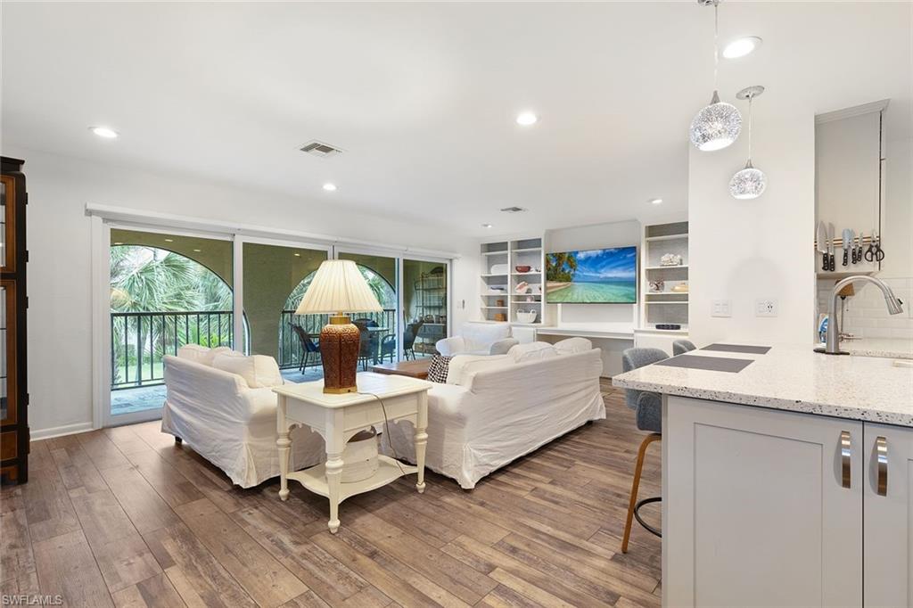 3360 10th Street North, Unit 1210 Naples, FL 34103 - Photo 8 of 28 a living room with furniture and a large window