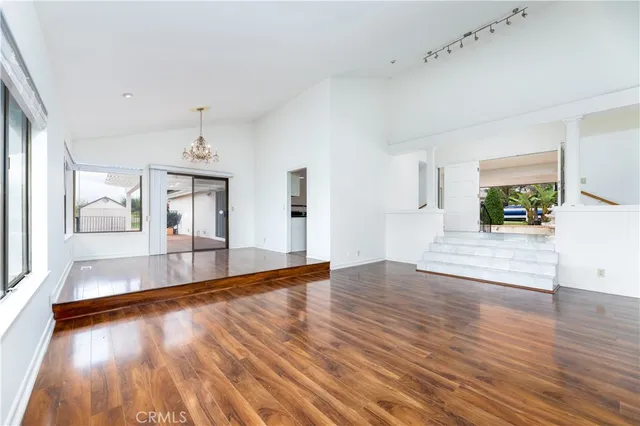 a view of empty room with wooden floor and fireplace