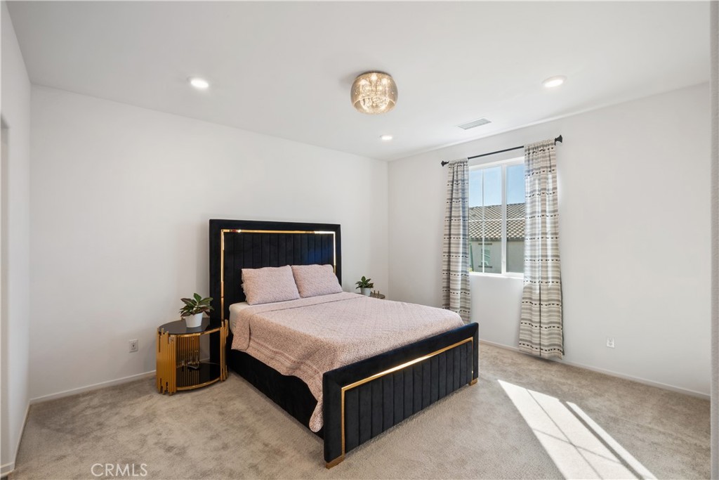5604 Altamura Way, Unit 10 Fontana, CA 92336 - Photo 11 of 38 a bed sitting in a spacious bedroom next to a window