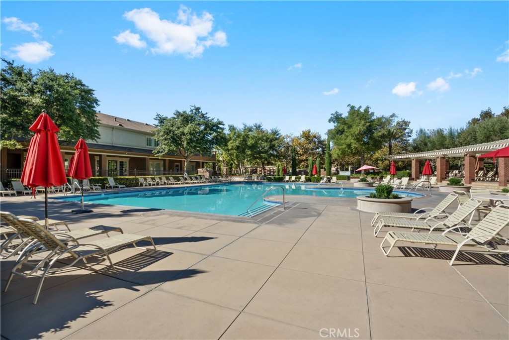 5604 Altamura Way, Unit 10 Fontana, CA 92336 - Photo 21 of 38 a view of swimming pool with lounge chair and dinning table under an umbrella