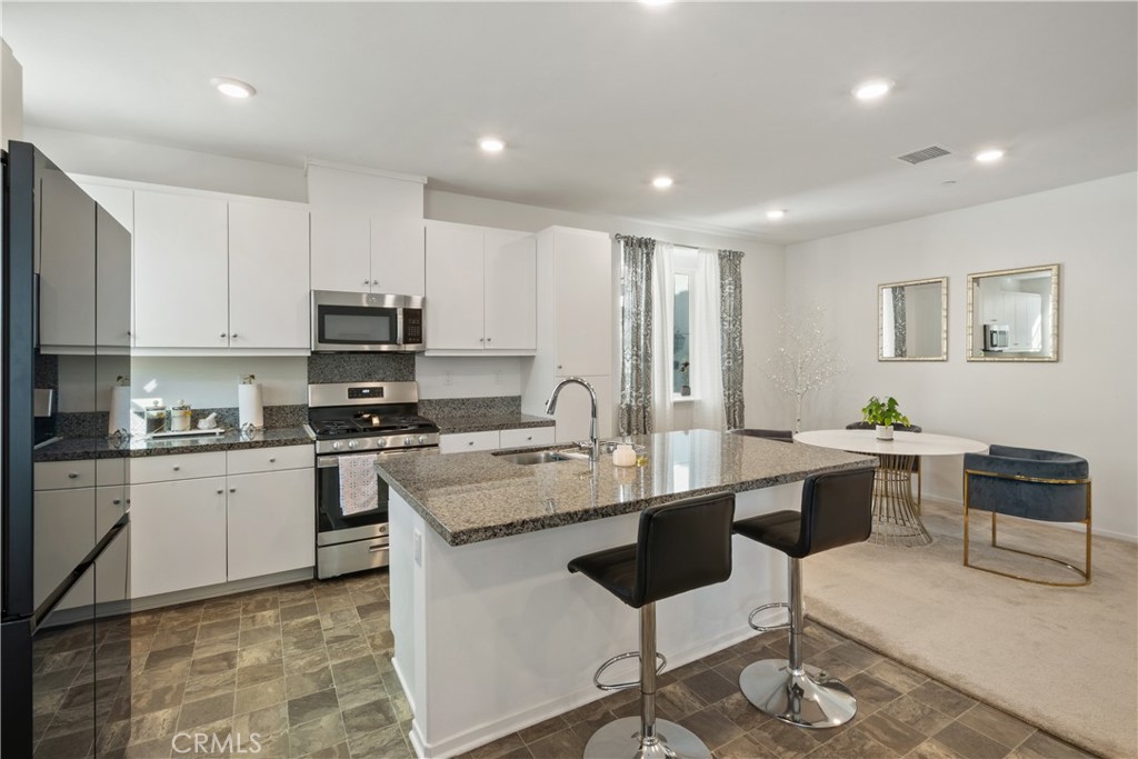 5604 Altamura Way, Unit 10 Fontana, CA 92336 - Photo 6 of 38 a room with stainless steel appliances kitchen island granite countertop a sink and cabinets
