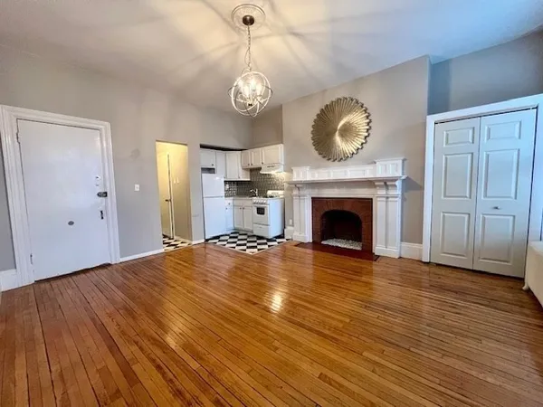 a view of an empty room with a fireplace and a window