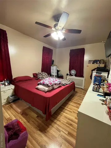 a bedroom with a bed and a dresser with the outer view