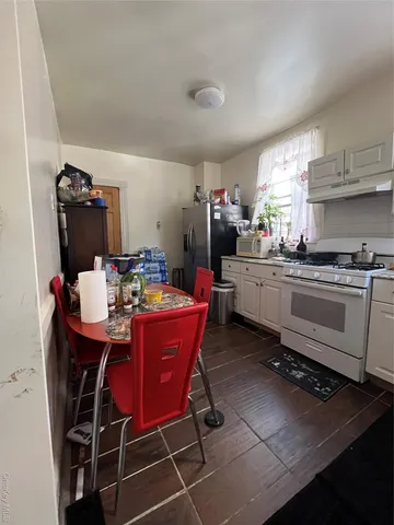 a kitchen with a sink a stove a dining table and chairs