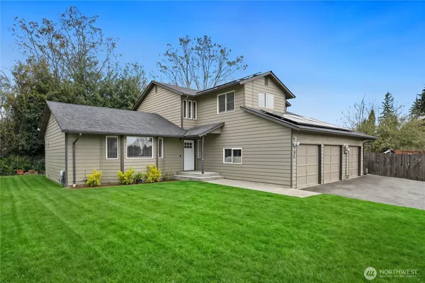 a front view of a house with a garden and yard