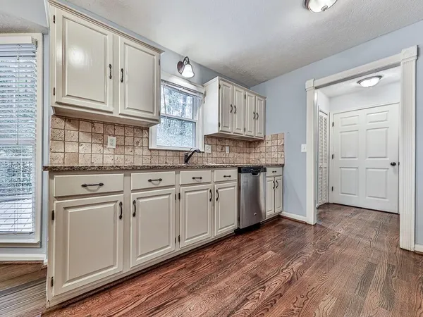 a kitchen with granite countertop white cabinets and white appliances