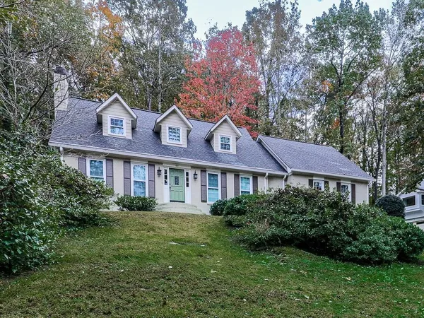 a front view of a house with a yard and trees