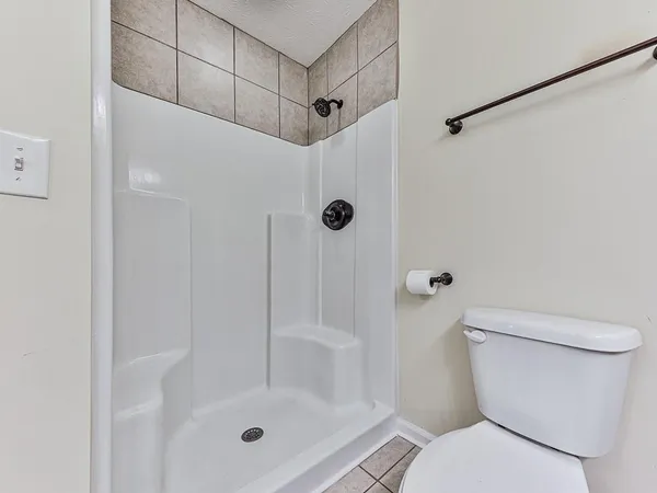 a bathroom with a shower a toilet and a shower