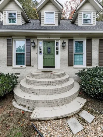 a white house with tree in front of it