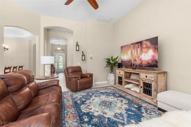 a living room with furniture a ceiling fan and a flat screen tv