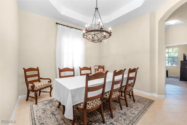 a bed sitting in a bedroom next to a window and a chandelier
