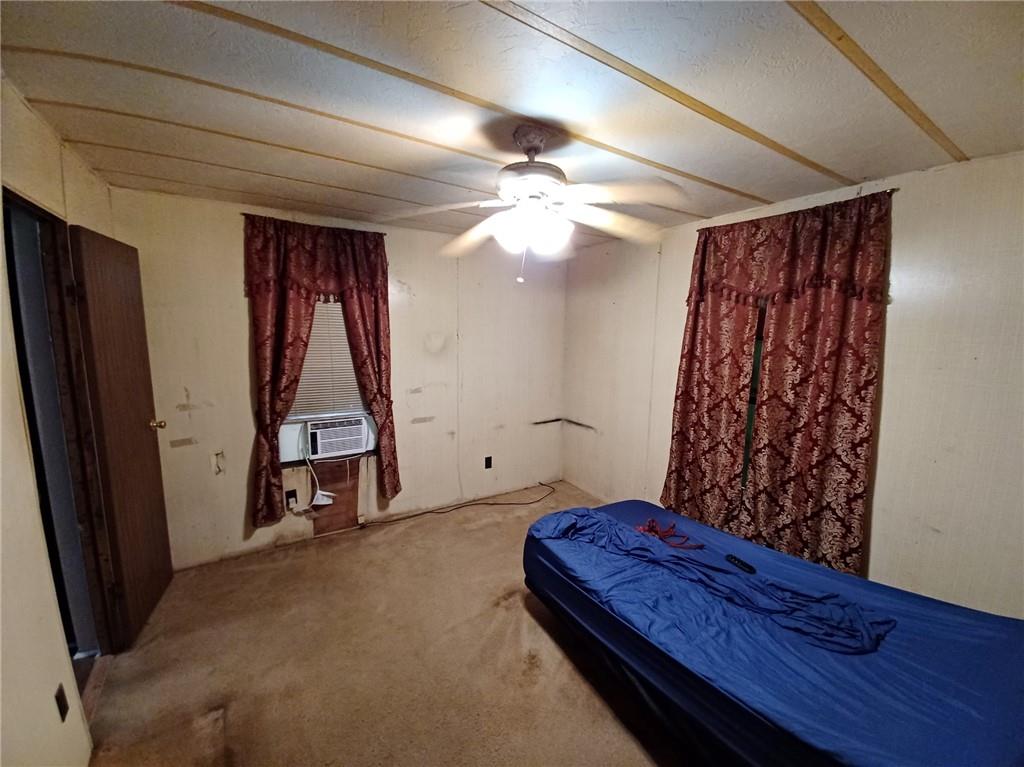 Bedroom with carpet, cooling unit, and ceiling fan