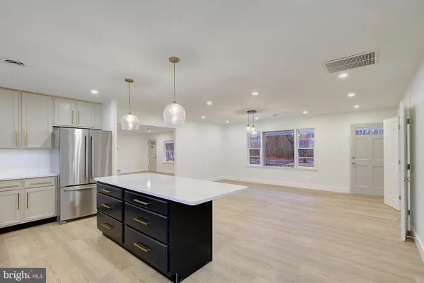 a kitchen with kitchen island a sink stainless steel appliances and a counter top space