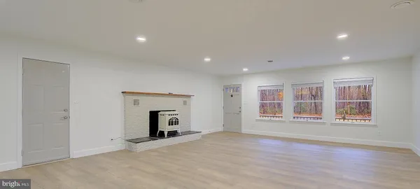 a view of an empty room with furniture and window