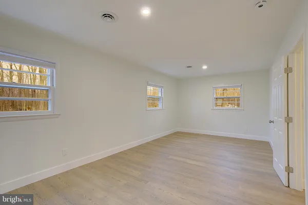 a view of an empty room with a fireplace and a window