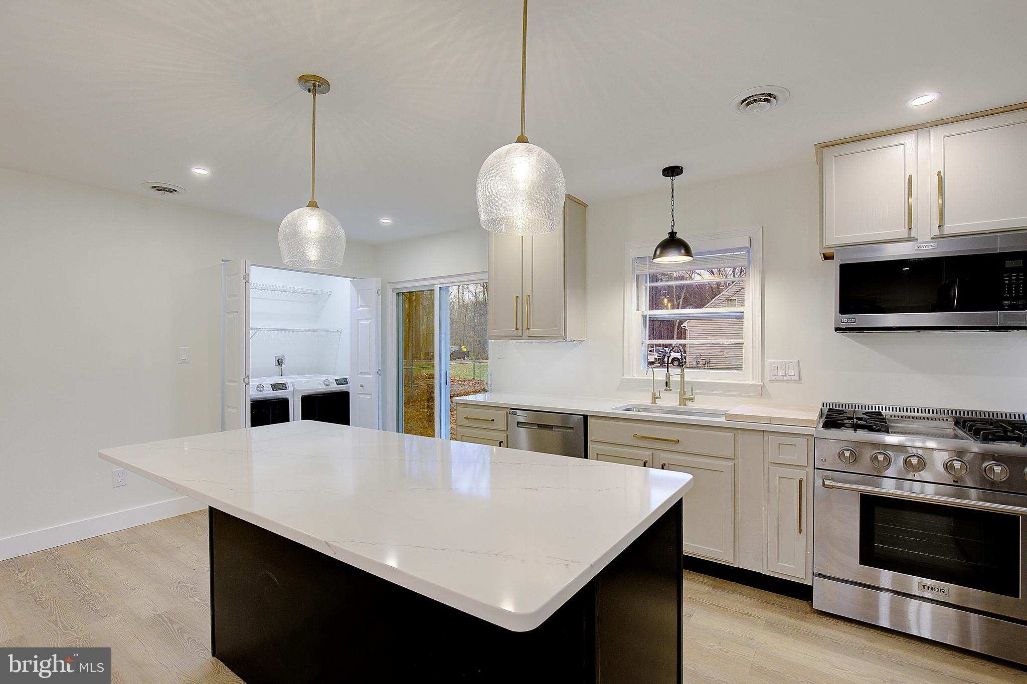 5823 Deale Beach Road Deale, MD 20751 - Photo 8 of 15 a kitchen with stainless steel appliances a stove a sink a microwave a center island and cabinets