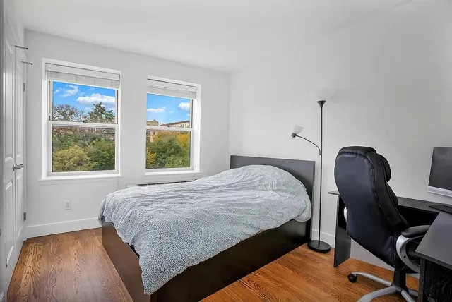 a bedroom with a bed a chair and a window