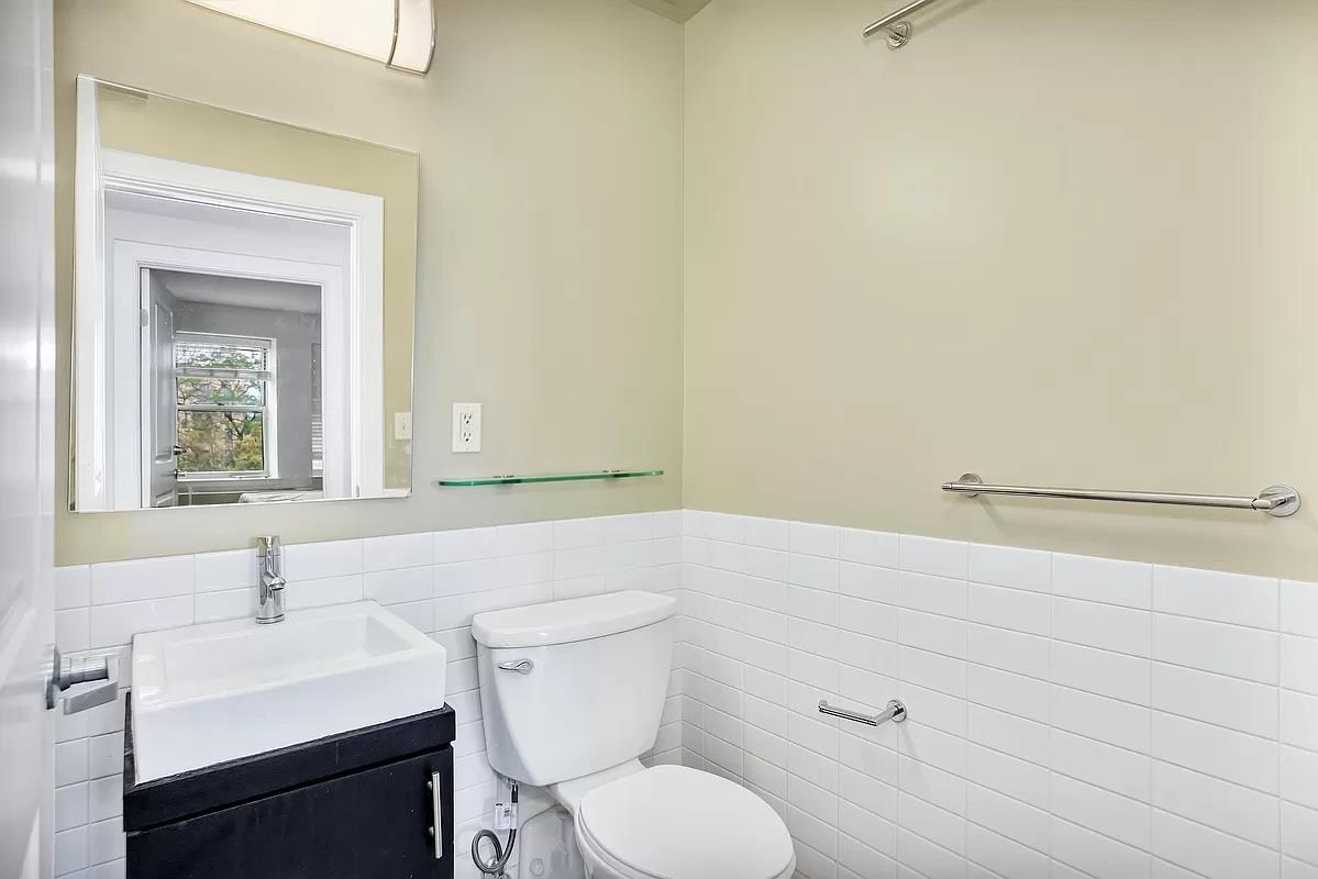 362 St Nicholas Avenue, Unit 9A Manhattan, NY 10027 - Photo 7 of 12 a bathroom with a toilet a sink and mirror