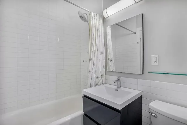 a bathroom with a sink toilet vanity and shower