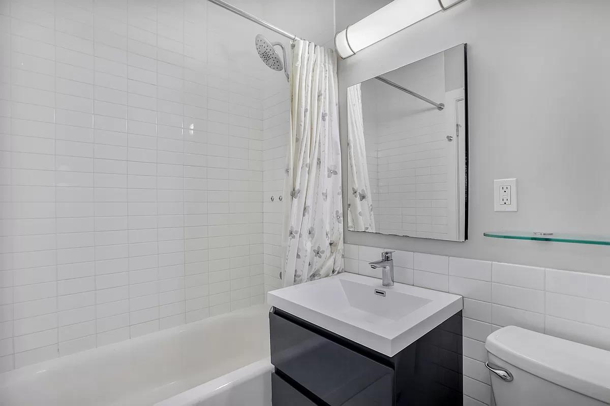 362 St Nicholas Avenue, Unit 9A Manhattan, NY 10027 - Photo 8 of 12 a bathroom with a sink toilet vanity and shower