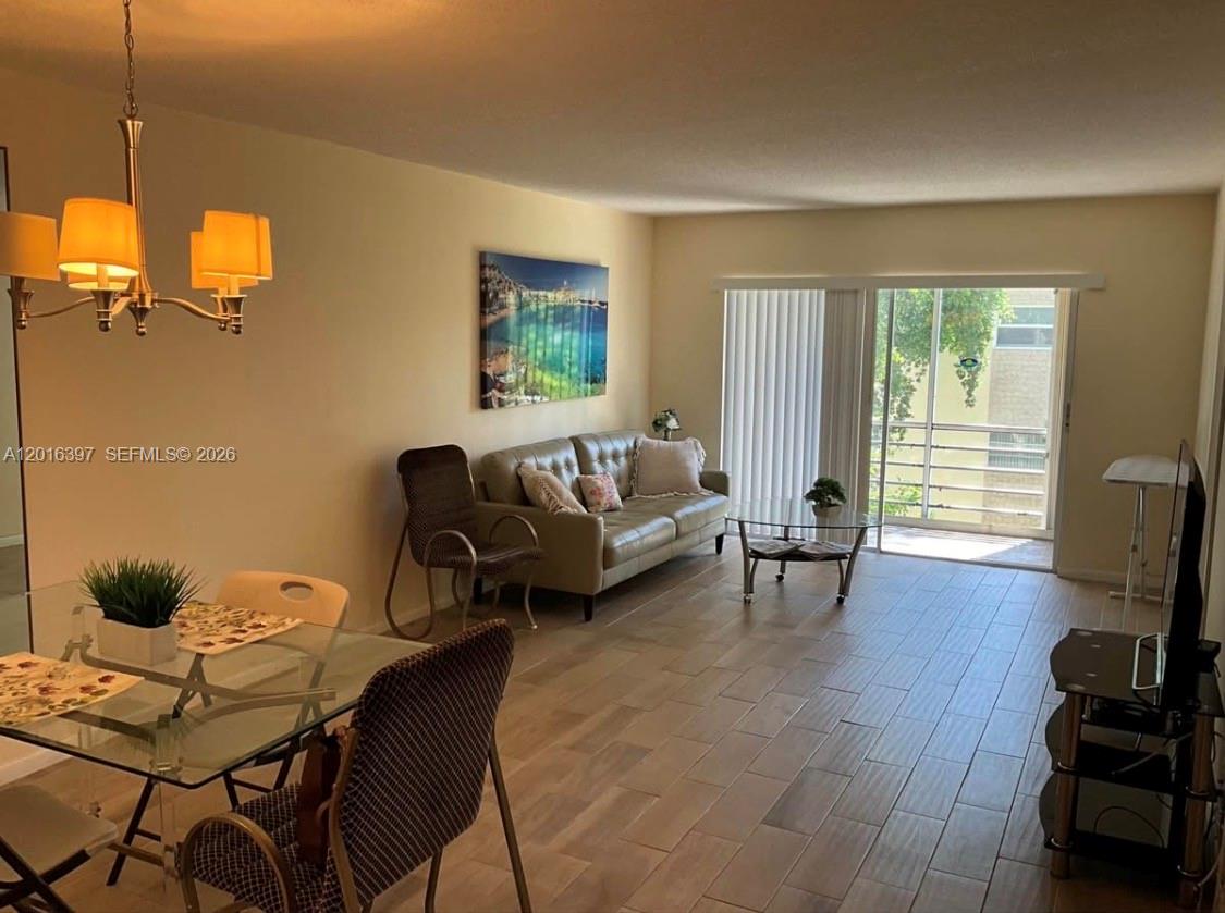 151 Berkley Road, Unit 303 Hollywood, FL 33024 - Photo 1 of 11 a living room with furniture and a flat screen tv