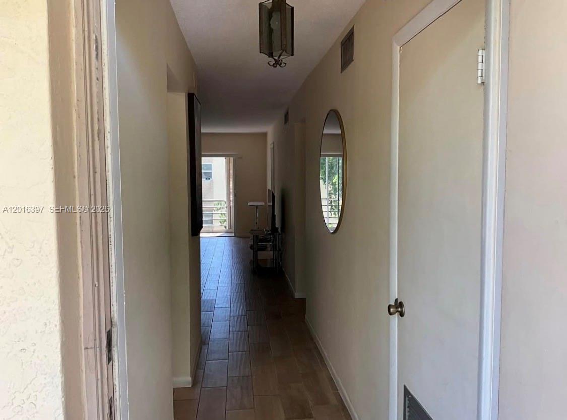 151 Berkley Road, Unit 303 Hollywood, FL 33024 - Photo 2 of 11 a view of a hallway with wooden floor