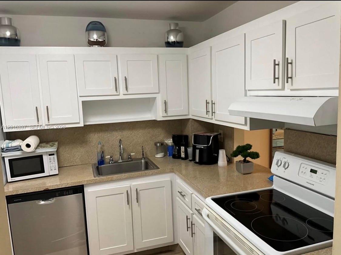 151 Berkley Road, Unit 303 Hollywood, FL 33024 - Photo 3 of 11 a kitchen with cabinets a sink and appliances