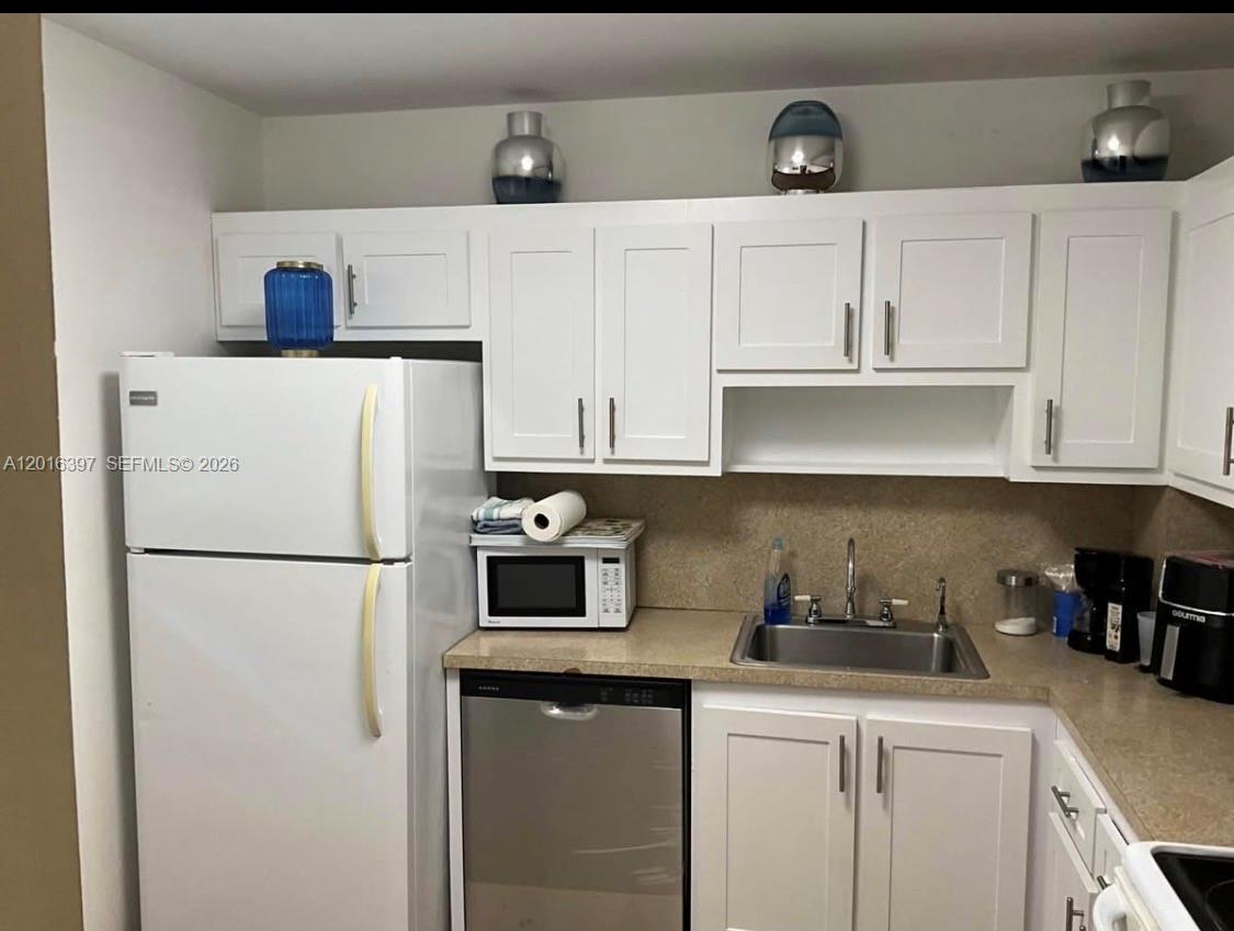 151 Berkley Road, Unit 303 Hollywood, FL 33024 - Photo 4 of 11 a white refrigerator freezer sitting in a kitchen
