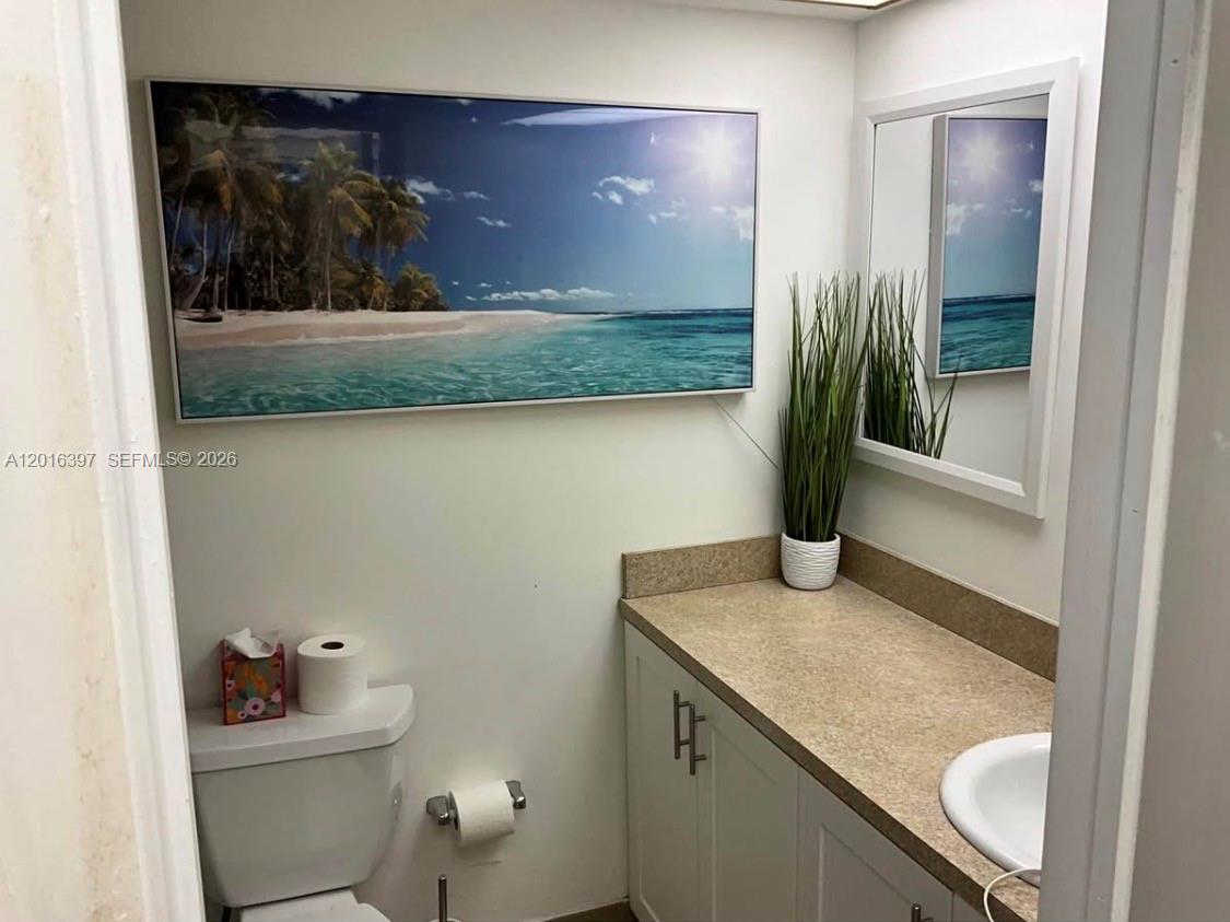 151 Berkley Road, Unit 303 Hollywood, FL 33024 - Photo 6 of 11 a bathroom with a granite countertop sink and mirror