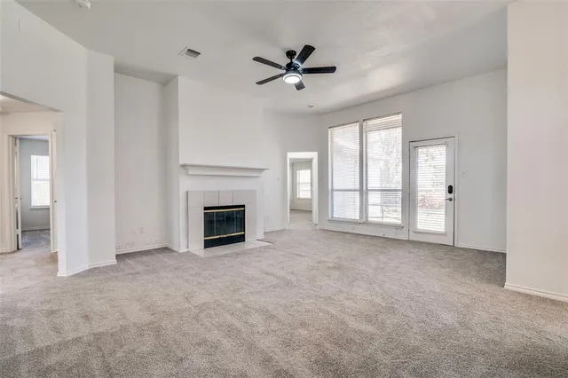a view of an empty room with a fireplace and a window