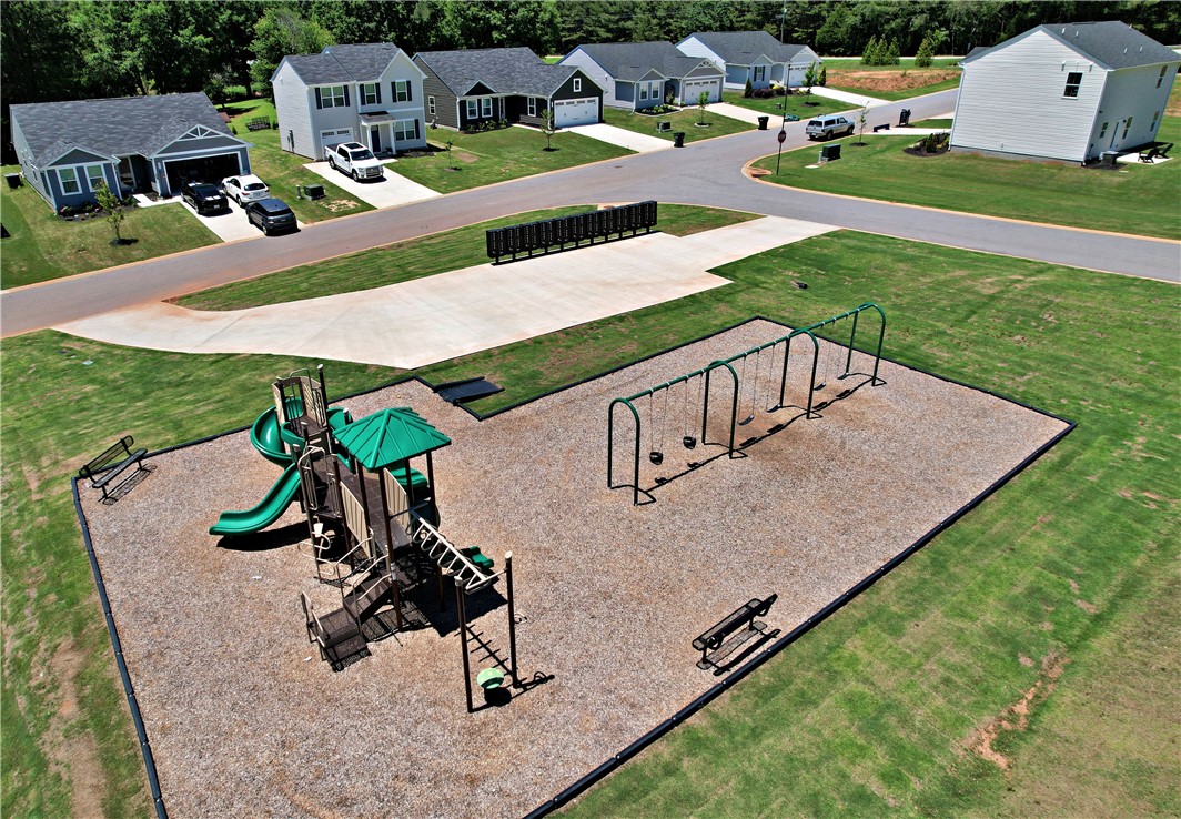 723 Peridot Way Westminster, SC 29693 - Photo 42 of 45 A neighborhood playground offers recreational space for residents, featuring a play structure and swings amidst residential homes.
