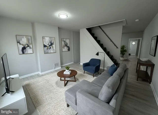 a living room with furniture and stairs