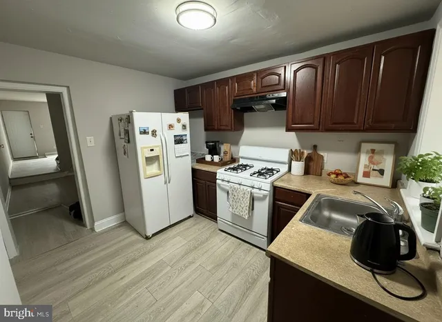 a kitchen with a refrigerator a stove and a cabinets