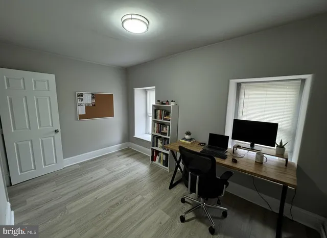 a view of a workspace with furniture and wooden floor