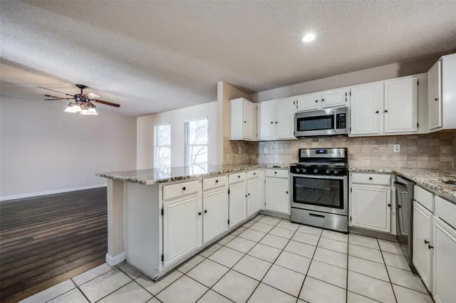 a kitchen with stainless steel appliances a sink window and cabinets