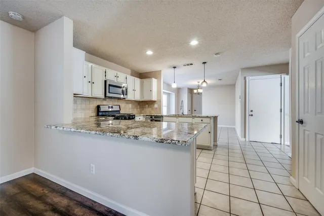a kitchen with stainless steel appliances granite countertop a sink and cabinets