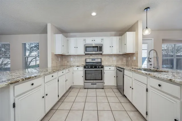 a kitchen with granite countertop white cabinets and white appliances