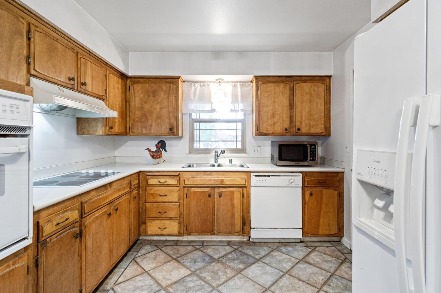 918 East Griffith Way Fresno, CA 93704 - Photo 3 of 21 a kitchen with stainless steel appliances granite countertop white cabinets a sink and a window