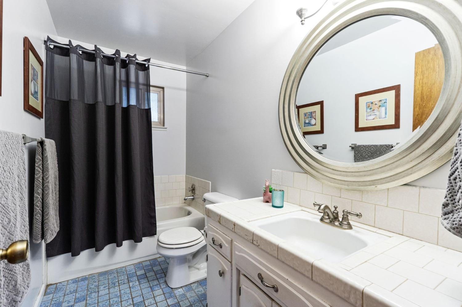 918 East Griffith Way Fresno, CA 93704 - Photo 8 of 21 a bathroom with a sink a toilet and a mirror