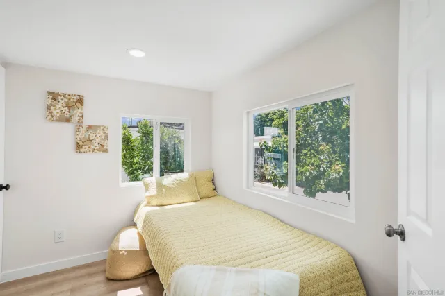 a bed sitting in a bedroom next to a window