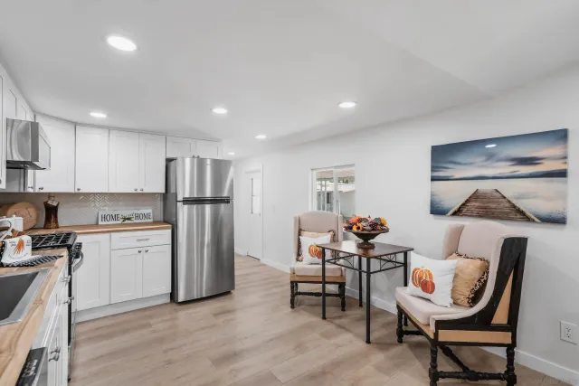 a kitchen with refrigerator and chairs