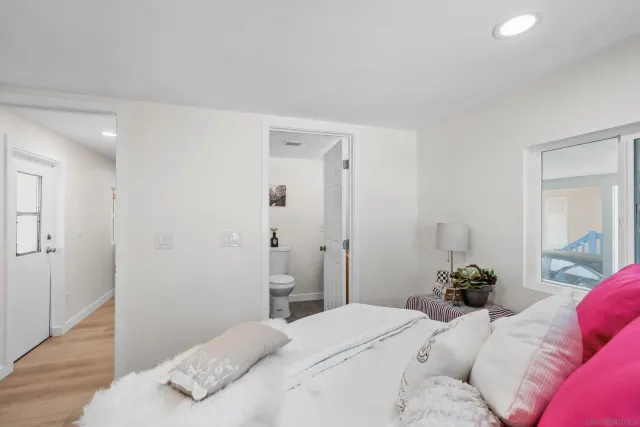 a bedroom with a bed and a potted plant