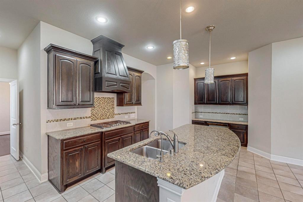 6723 Capistrano Street Irving, TX 75039 - Photo 11 of 40 a kitchen with kitchen island granite countertop a sink and stainless steel appliances