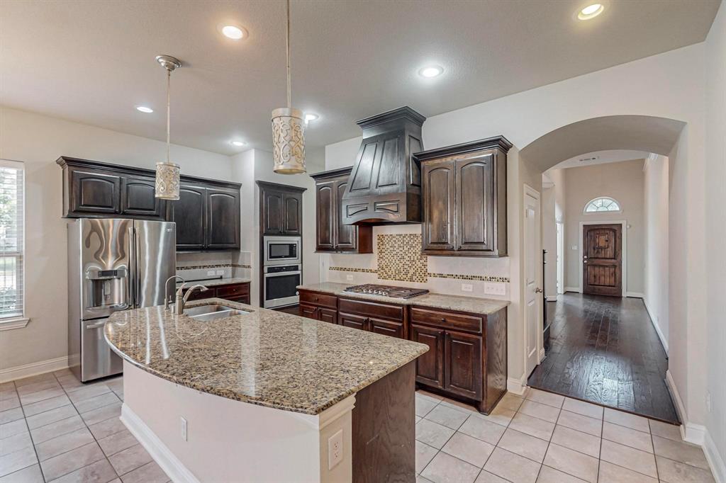 6723 Capistrano Street Irving, TX 75039 - Photo 12 of 40 a kitchen with stainless steel appliances granite countertop a sink refrigerator and cabinets