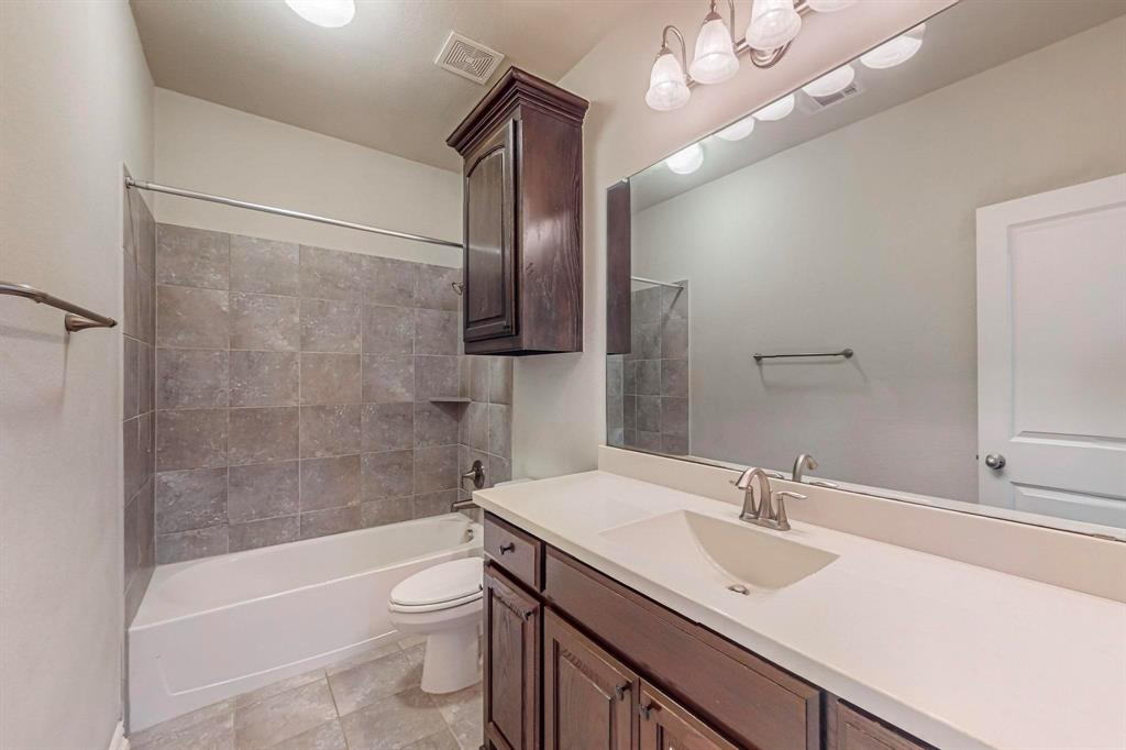 6723 Capistrano Street Irving, TX 75039 - Photo 14 of 40 a bathroom with a sink a toilet a mirror and shower