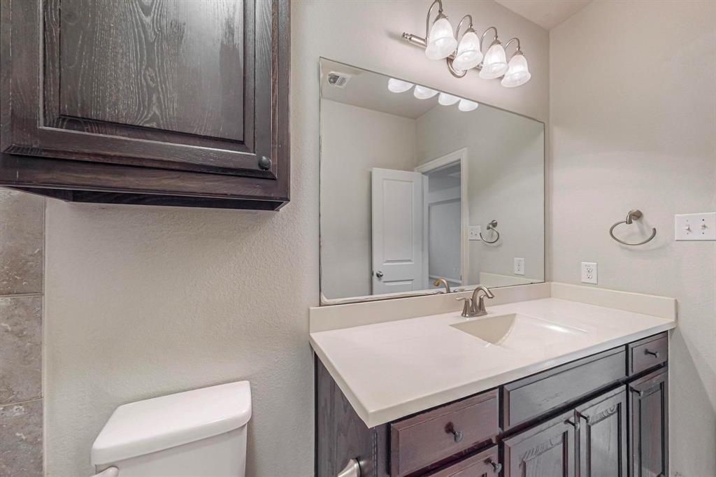 6723 Capistrano Street Irving, TX 75039 - Photo 15 of 40 a bathroom with a sink a toilet and mirror