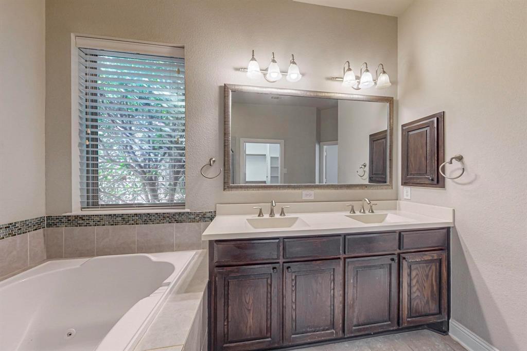 6723 Capistrano Street Irving, TX 75039 - Photo 21 of 40 a bathroom with a tub a sink and mirror